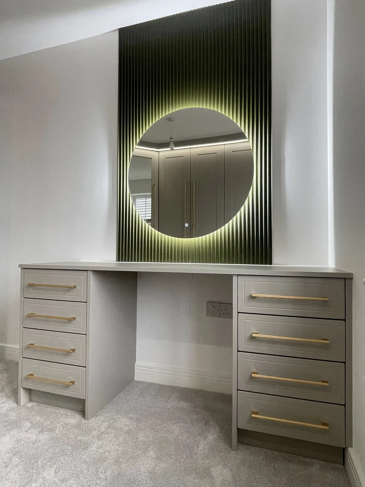 Grey fitted dressing table with an illuminated round mirror