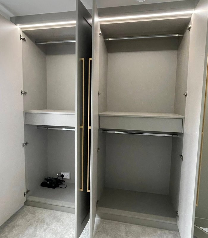Open fitted wardrobe interior with hanging rails and shelving