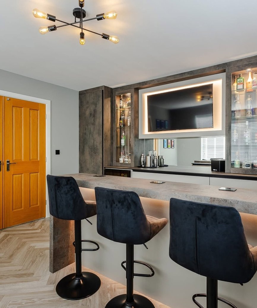 Fitted home bar with a television, display cabinets and built-in storage