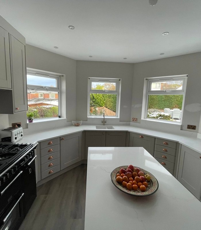 Grey U-shaped fitted kitchen with a peninsula and range cooker