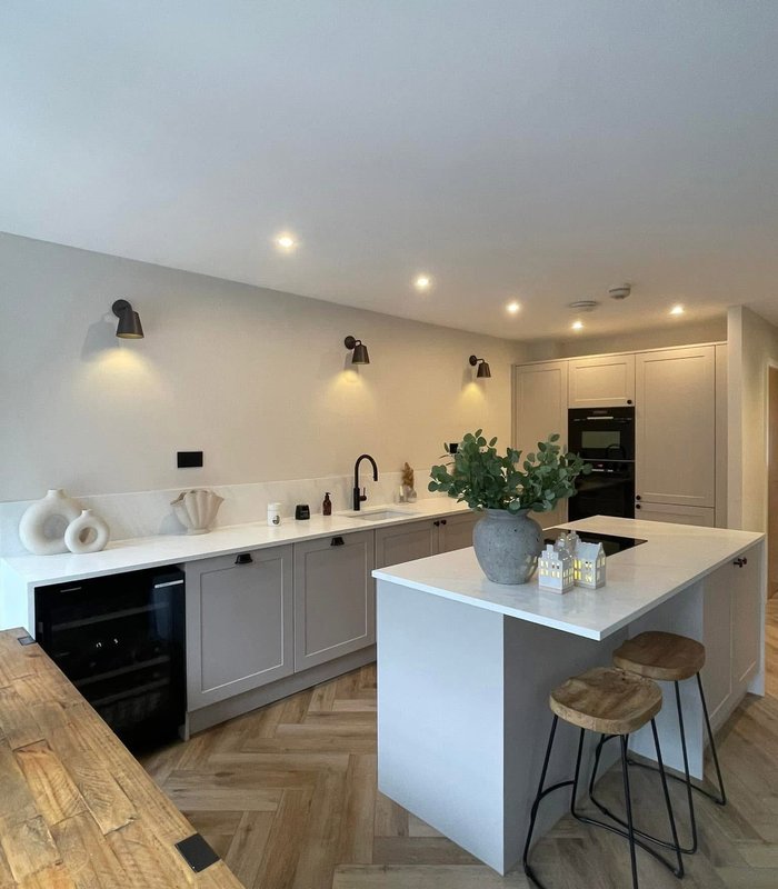 Light grey kitchen with an island, breakfast bar and wine cooler