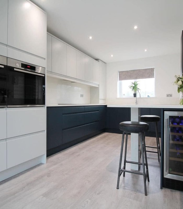 White and charcoal handleless kitchen with a breakfast bar and wine cooler
