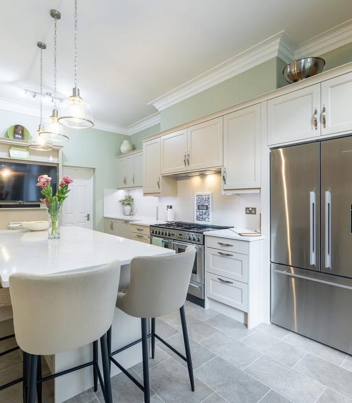 Light shaker kitchen with an island and American-style fridge