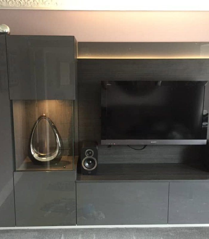Dark grey media wall with a television, speakers and storage