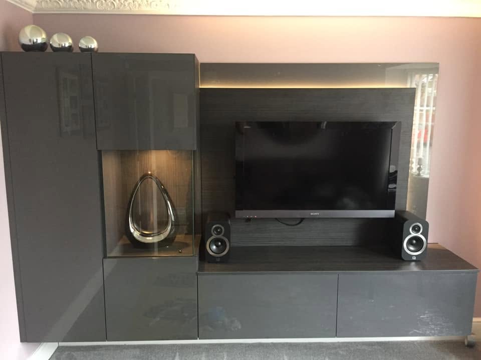 Dark grey media wall with a television, speakers and storage