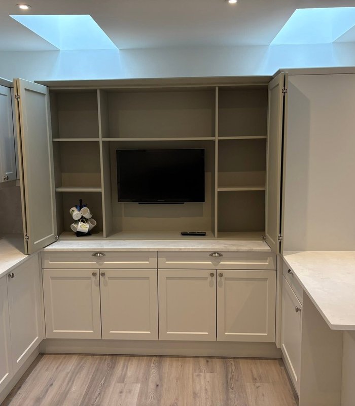 Light fitted media cabinetry with shelving and a built-in desk