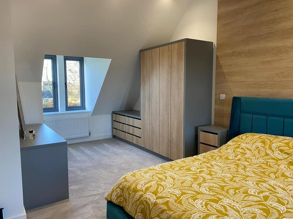 Wood-effect fitted wardrobes and drawers in an attic bedroom